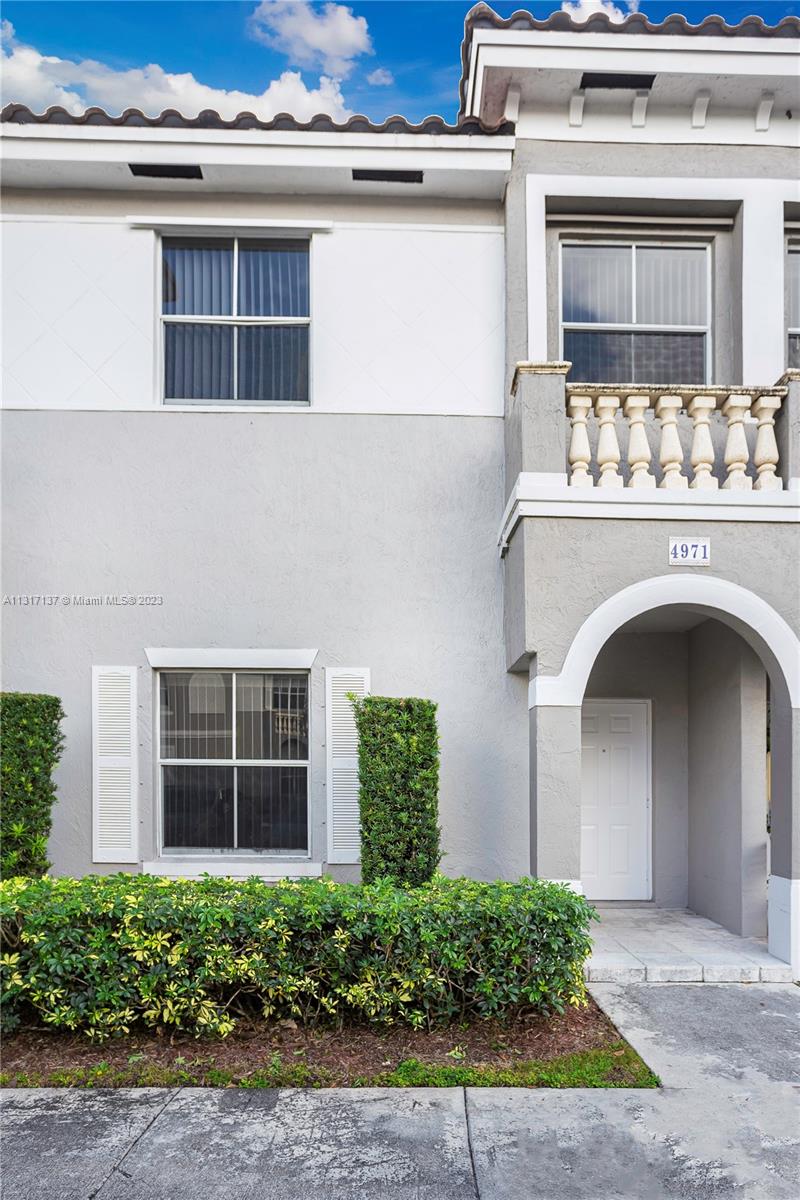 4971 Southwest 140th Terrace, Unit 6 Miramar, FL 33027 - Photo 2 of 24 a front view of a house with plants