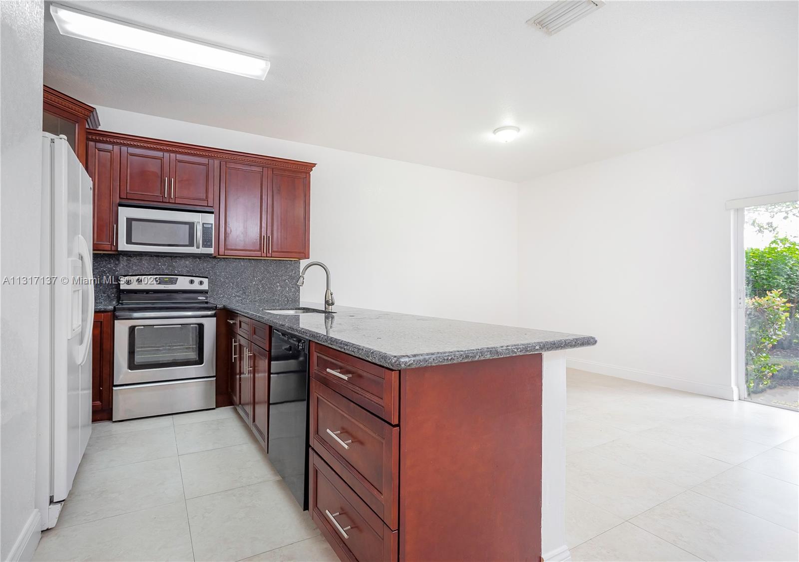 4971 Southwest 140th Terrace, Unit 6 Miramar, FL 33027 - Photo 9 of 24 a kitchen with stainless steel appliances granite countertop a stove a sink and a refrigerator