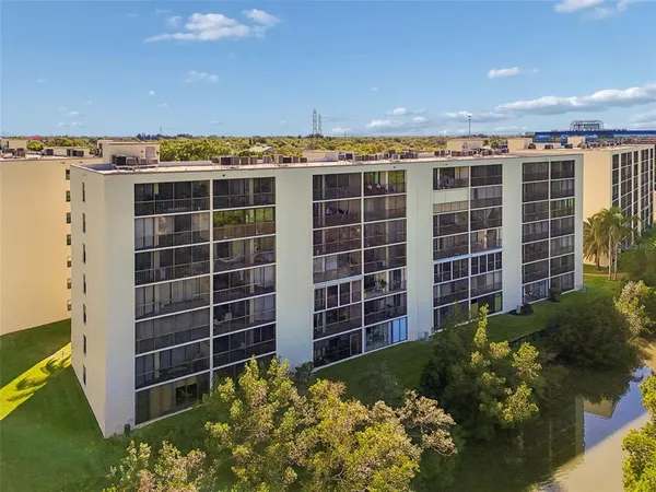 a view of a multi story residential apartment building with a yard