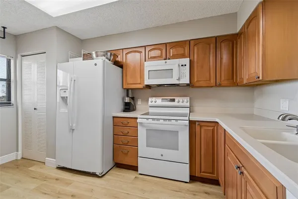 a dining room with wooden floor a chandelier a wooden table and chairs