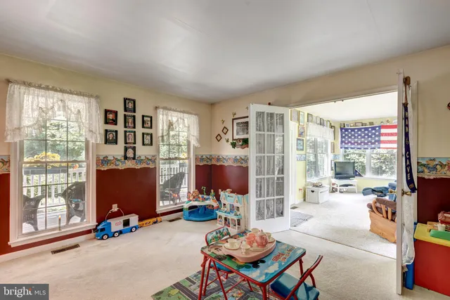 a living room with furniture a flat screen tv and a floor to ceiling window