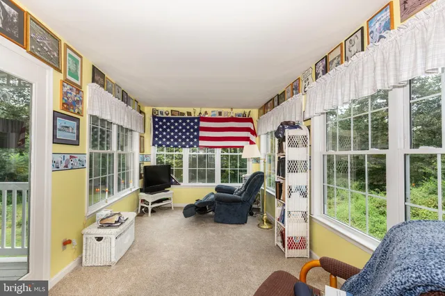 a view of a porch with furniture and floor to ceiling window
