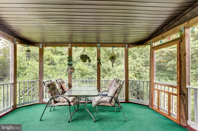 a view of a chairs and table in patio next to a yard