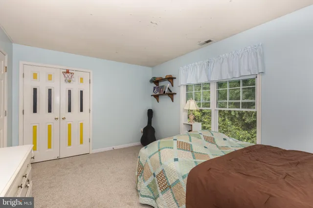 a bed sitting in a bedroom next to a window