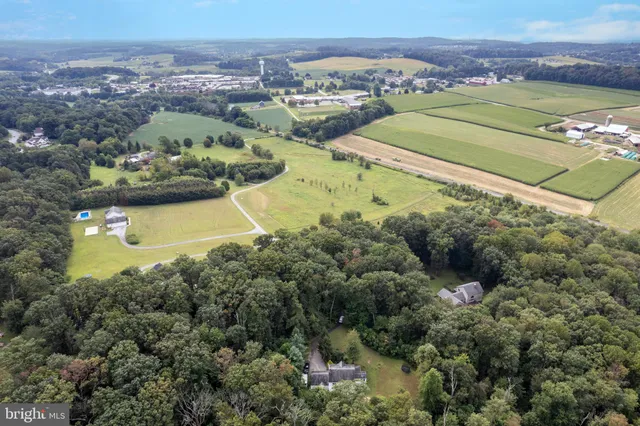 an aerial view of a residential houses with outdoor space and lake view