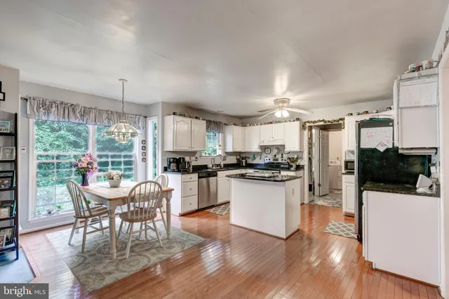 a kitchen with a table chairs refrigerator and microwave