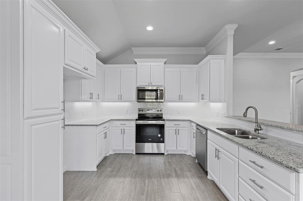 624 Jameson Springtown, TX 76082 - Photo 11 of 40 a kitchen with granite countertop white cabinets and white appliances