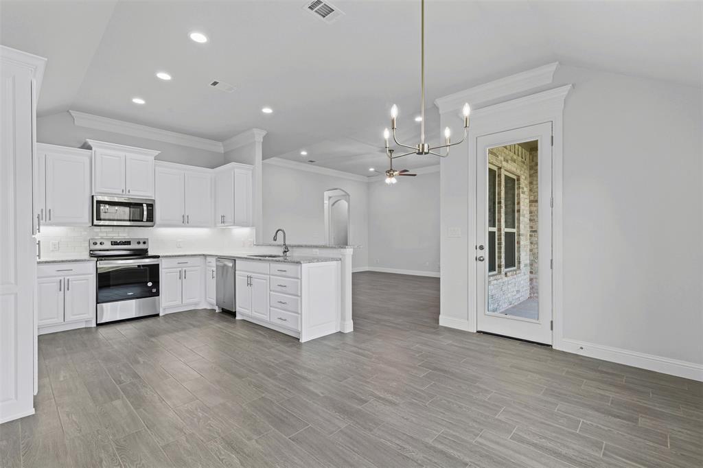 624 Jameson Springtown, TX 76082 - Photo 13 of 40 a large kitchen with cabinets a sink a counter space stainless steel appliances and cabinets