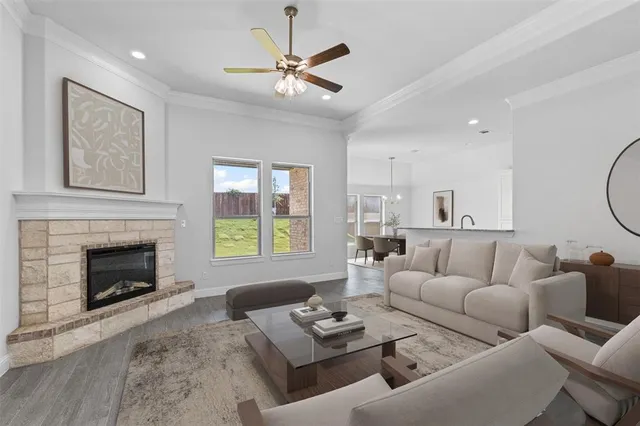 a living room with furniture a fireplace and a large window