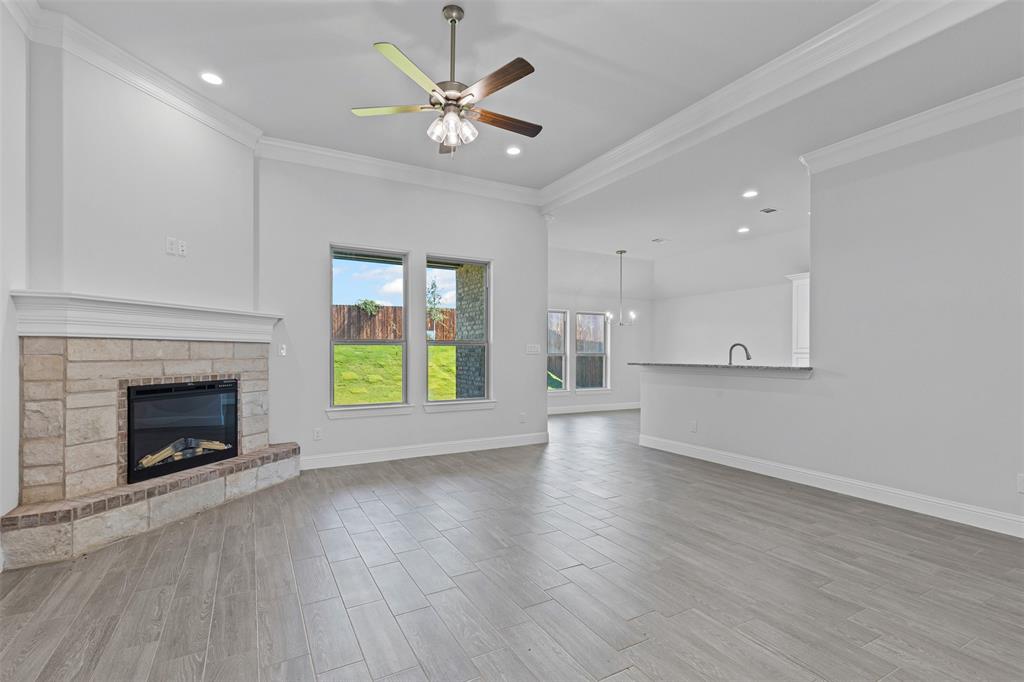624 Jameson Springtown, TX 76082 - Photo 7 of 40 an empty room with wooden floor fireplace and windows