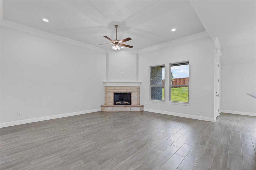 624 Jameson Springtown, TX 76082 - Photo 9 of 40 an empty room with windows fireplace and wooden floor