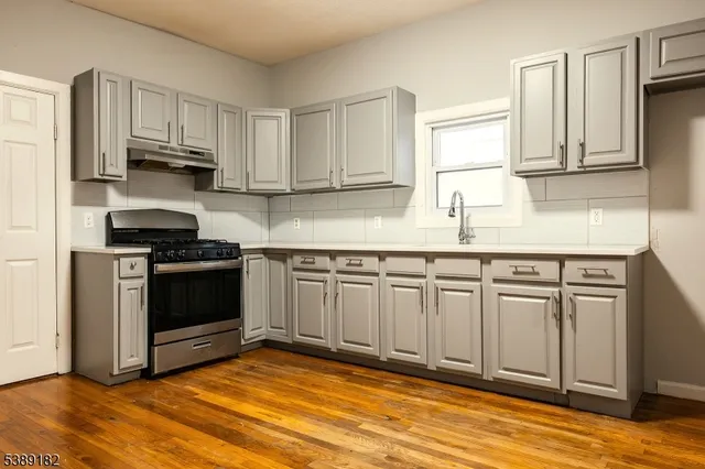 a kitchen with granite countertop a stove a sink and a granite counter tops