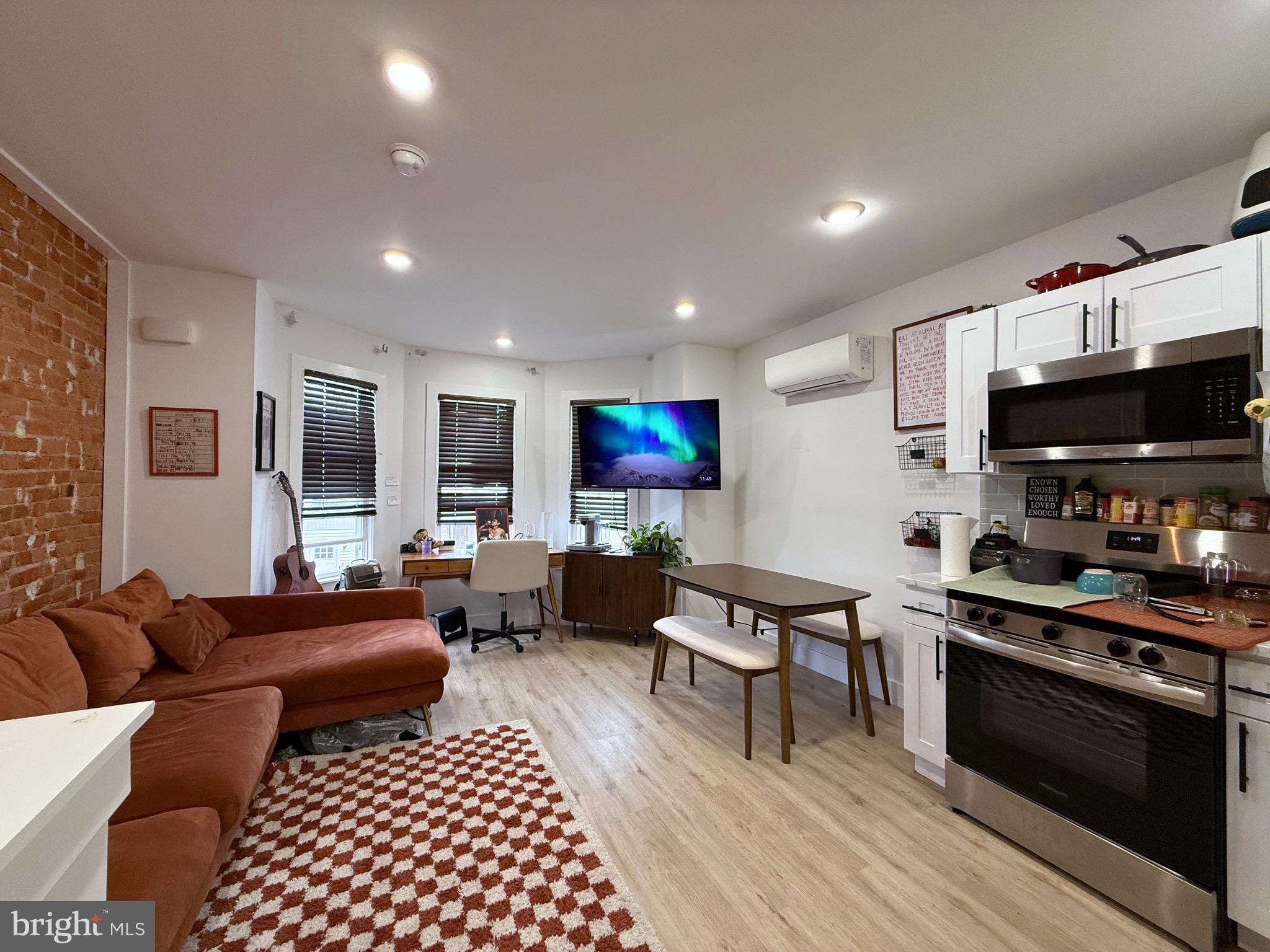 6136 Chancellor Street Philadelphia, PA 19139 - Photo 2 of 10 a living room with furniture a flat screen tv and kitchen view