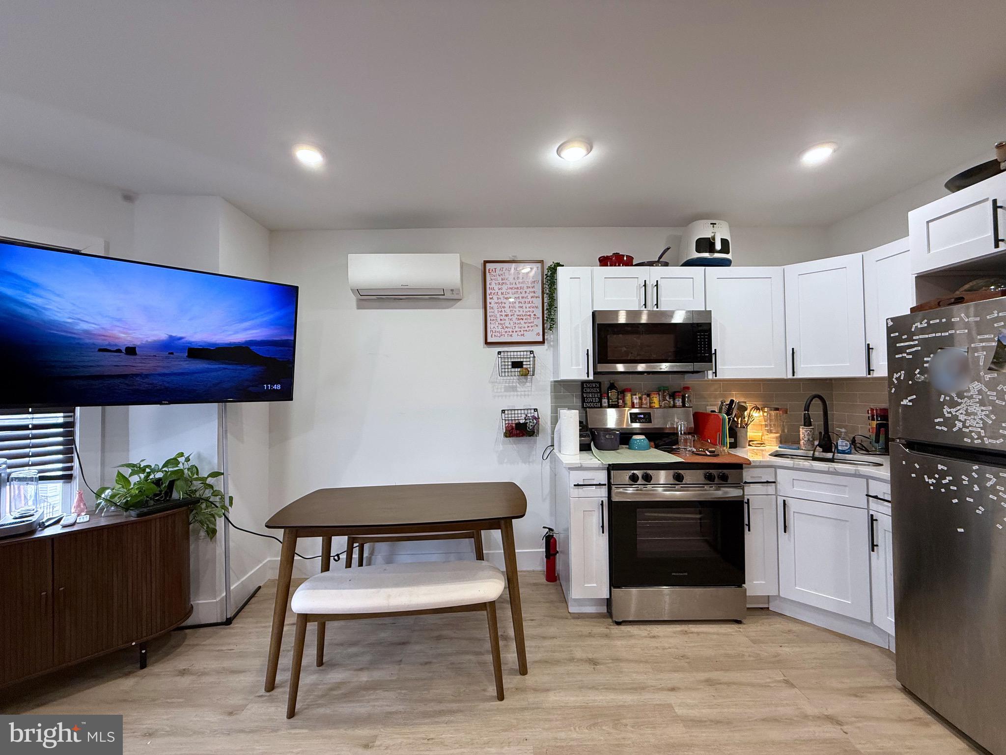 6136 Chancellor Street Philadelphia, PA 19139 - Photo 4 of 10 a kitchen with stainless steel appliances kitchen island granite countertop a stove top oven a sink dishwasher and a refrigerator with wooden cabinets