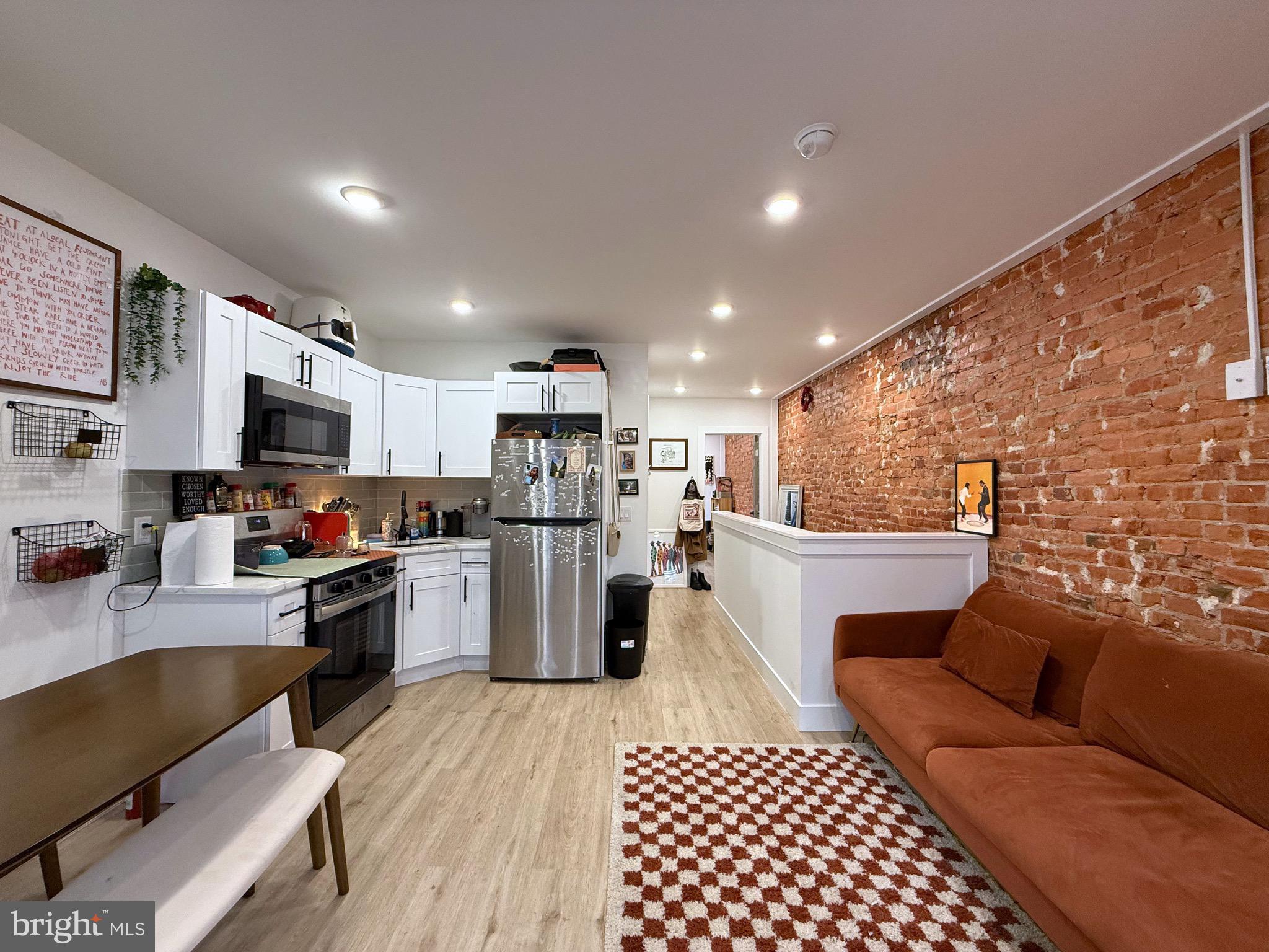 6136 Chancellor Street Philadelphia, PA 19139 - Photo 5 of 10 a kitchen with stainless steel appliances kitchen island granite countertop a refrigerator and a stove top oven