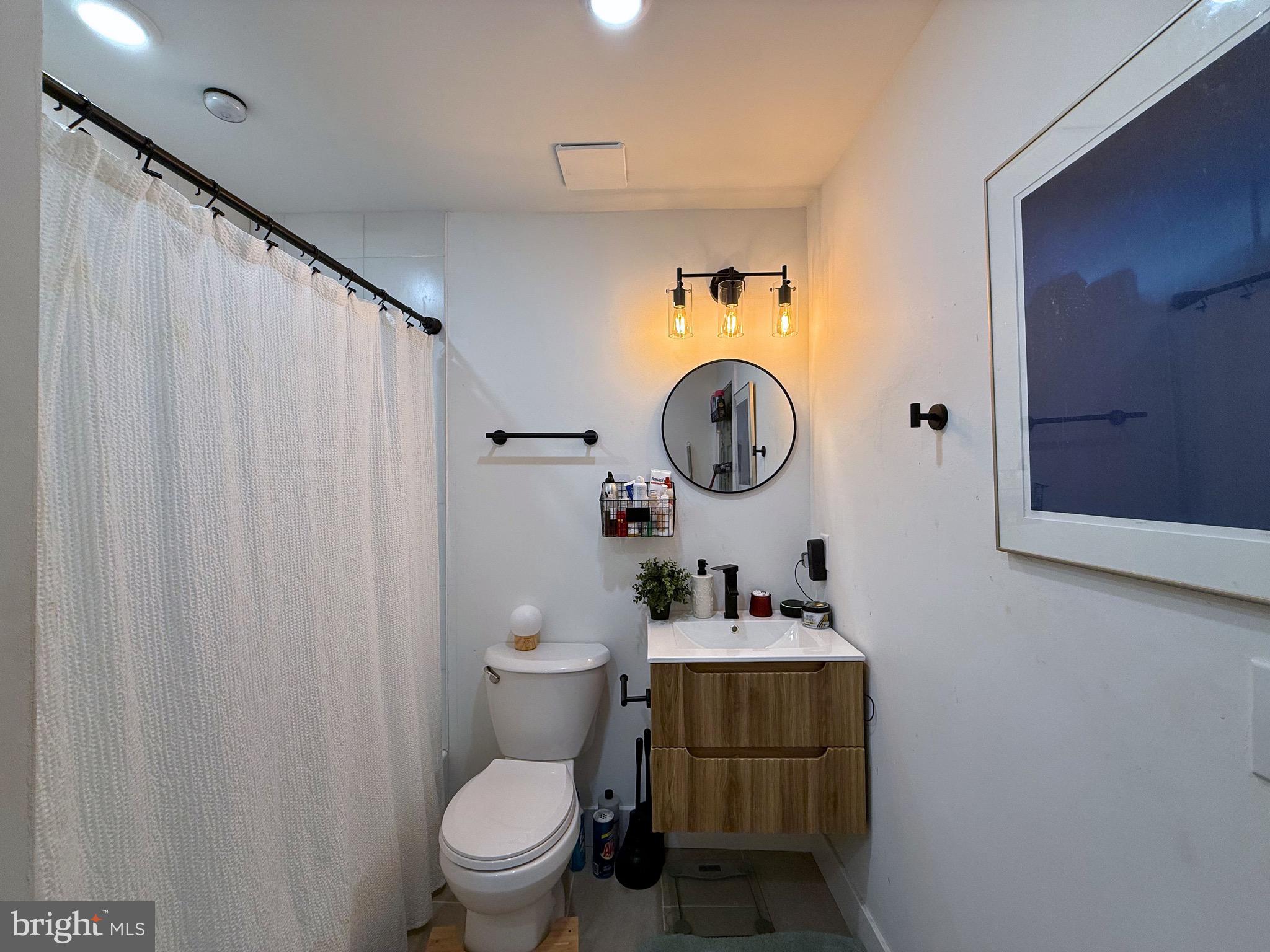 6136 Chancellor Street Philadelphia, PA 19139 - Photo 9 of 10 a bathroom with a toilet a sink and a mirror