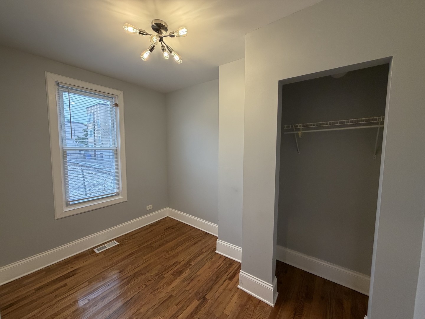 3614 West George Street, Unit 1R Chicago, IL 60618 - Photo 10 of 12 wooden floor in an empty room with a window