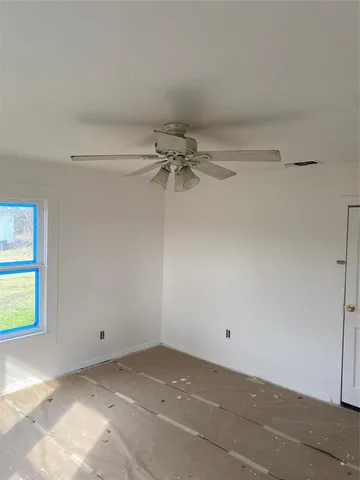 a view of a room with a ceiling fan and a window