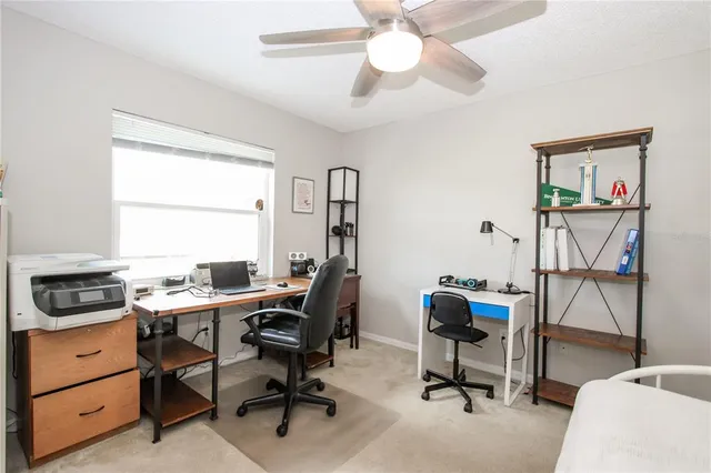 a view of a workspace with furniture and a window