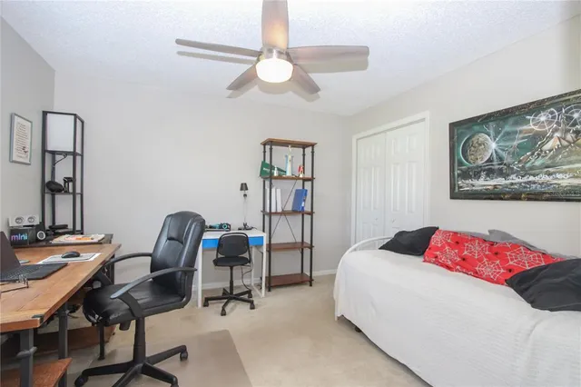 a bedroom with a bed a desk and chair with the bookshelf