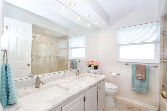 a bathroom with a granite countertop sink a mirror and a toilet