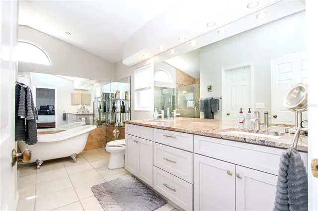 a large bathroom with a double vanity sink a mirror and a bathtub