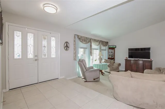 a living room with furniture a flat screen tv and a large window