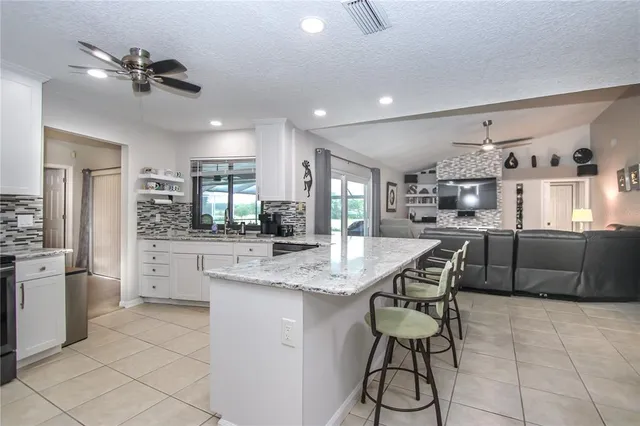 a kitchen with stainless steel appliances kitchen island granite countertop a sink and cabinets