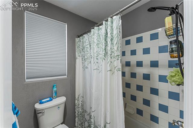 10158 Angeles Road Peyton, CO 80831 - Photo 26 of 43 Bathroom with toilet and shower / bathtub combination with curtain