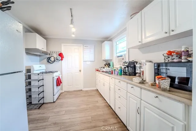 a kitchen with white cabinets and window