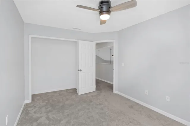 an empty room with a window and a fan