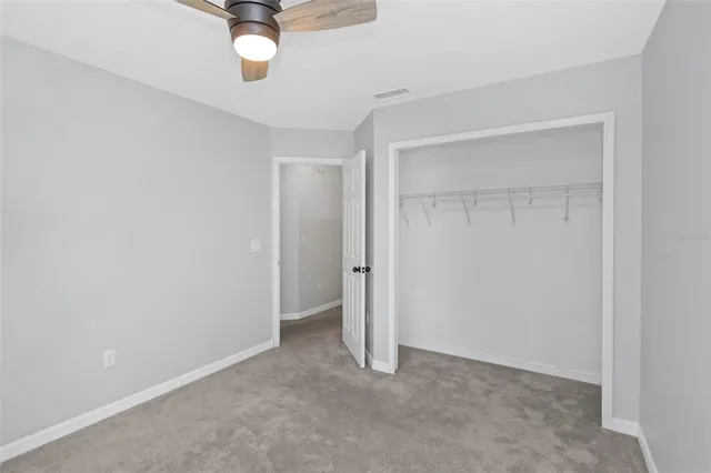 an empty room with a ceiling fan and shower