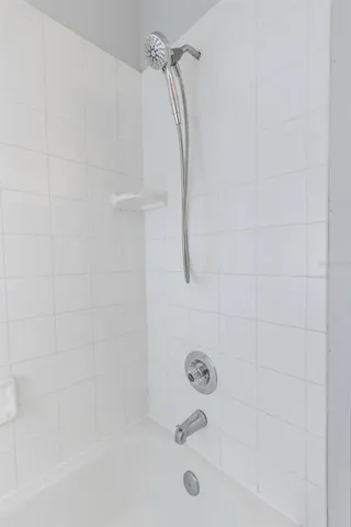 a bathroom with a bath tub with a shower