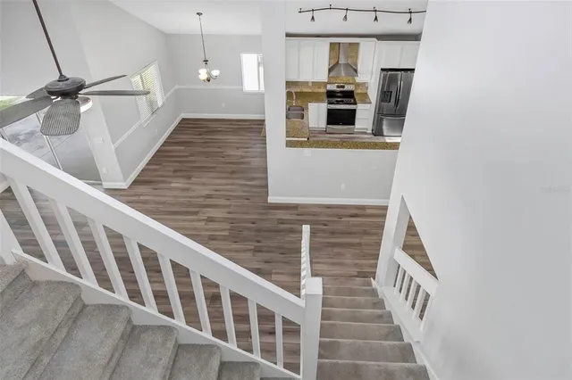 a view of a hallway with wooden floor and staircase
