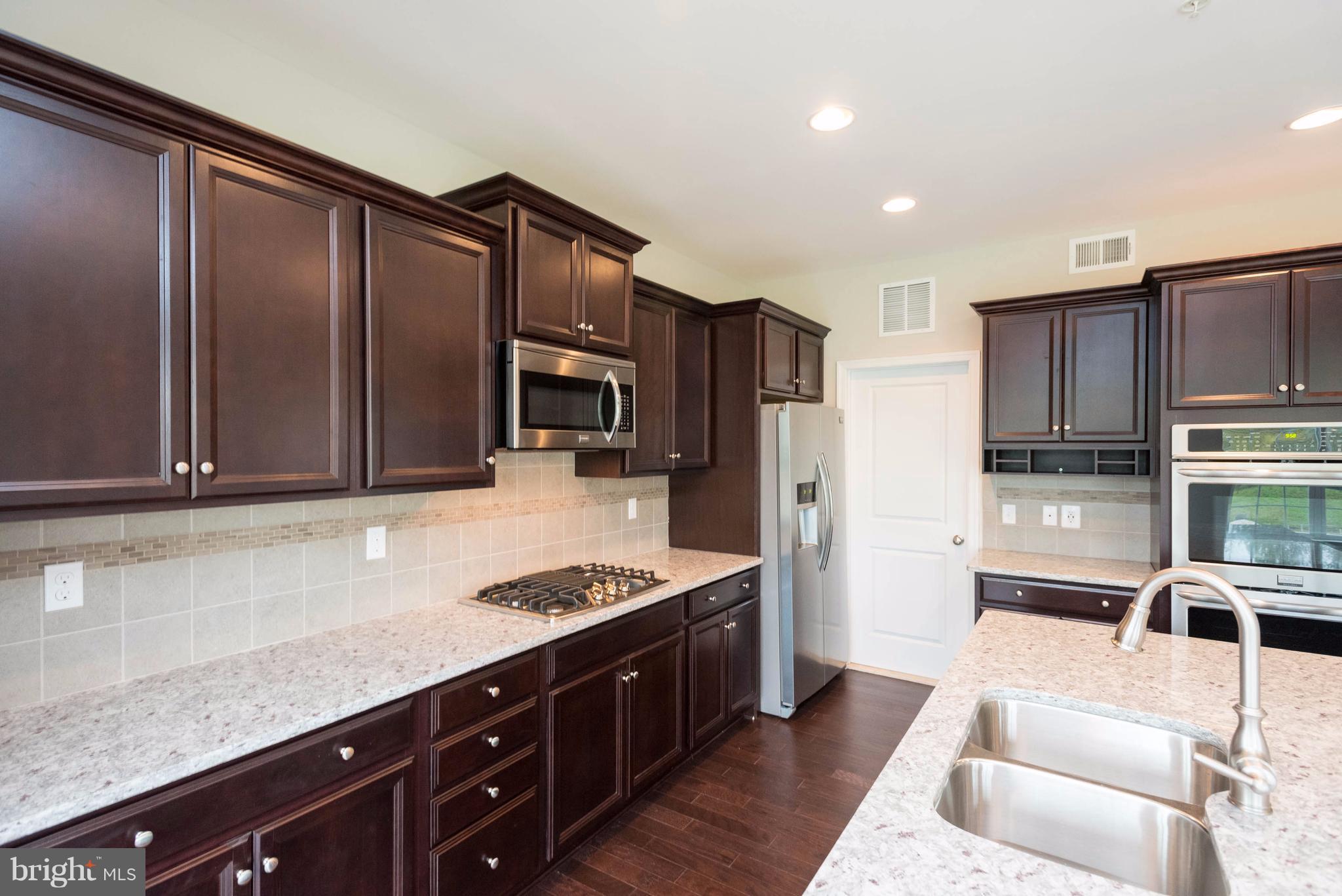 9766 Powder Hall Road Perry Hall, MD 21128 - Photo 11 of 30 a kitchen with stainless steel appliances granite countertop a refrigerator and a stove top oven