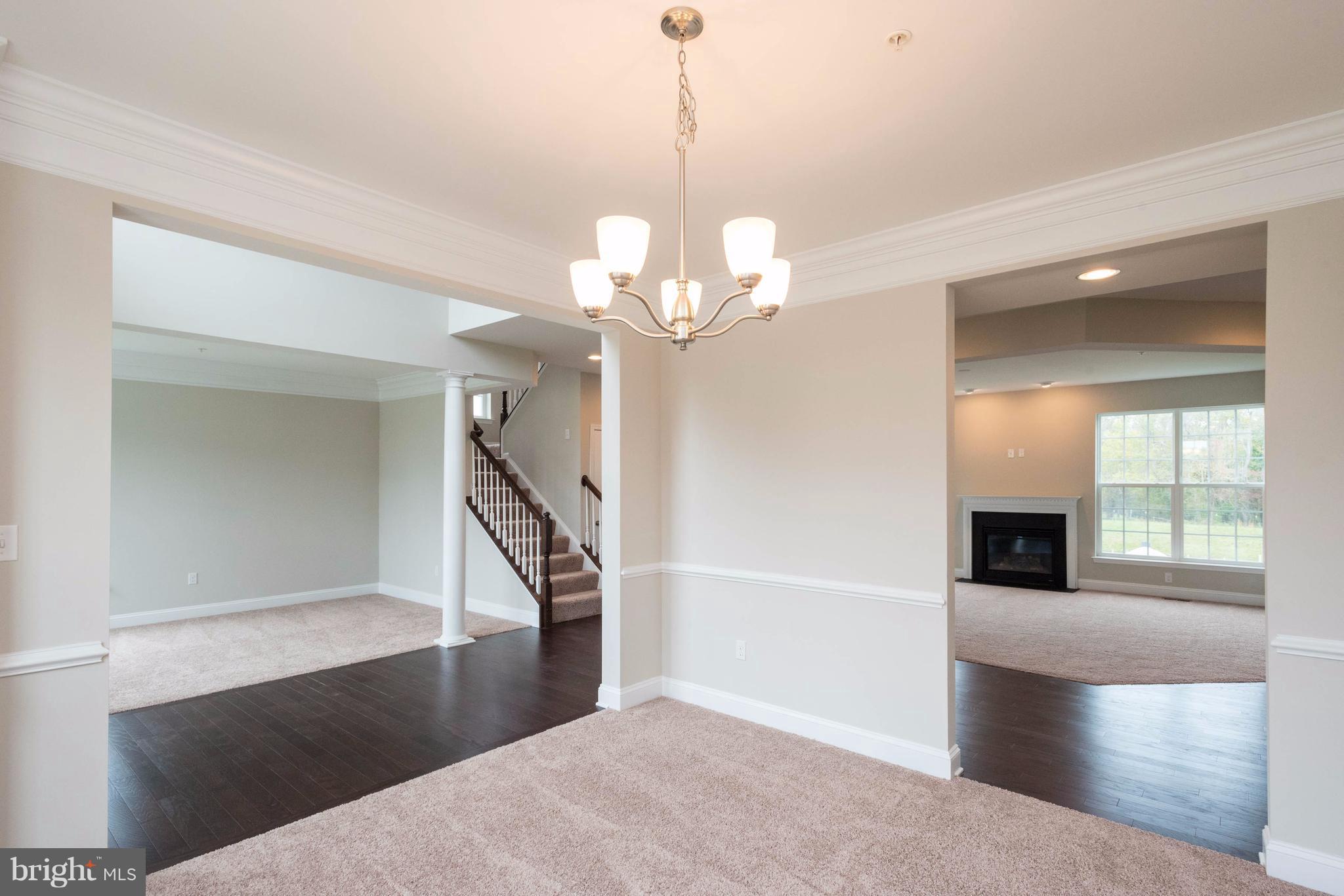 9766 Powder Hall Road Perry Hall, MD 21128 - Photo 5 of 30 a view of a livingroom with a fireplace wooden floor and a chandelier