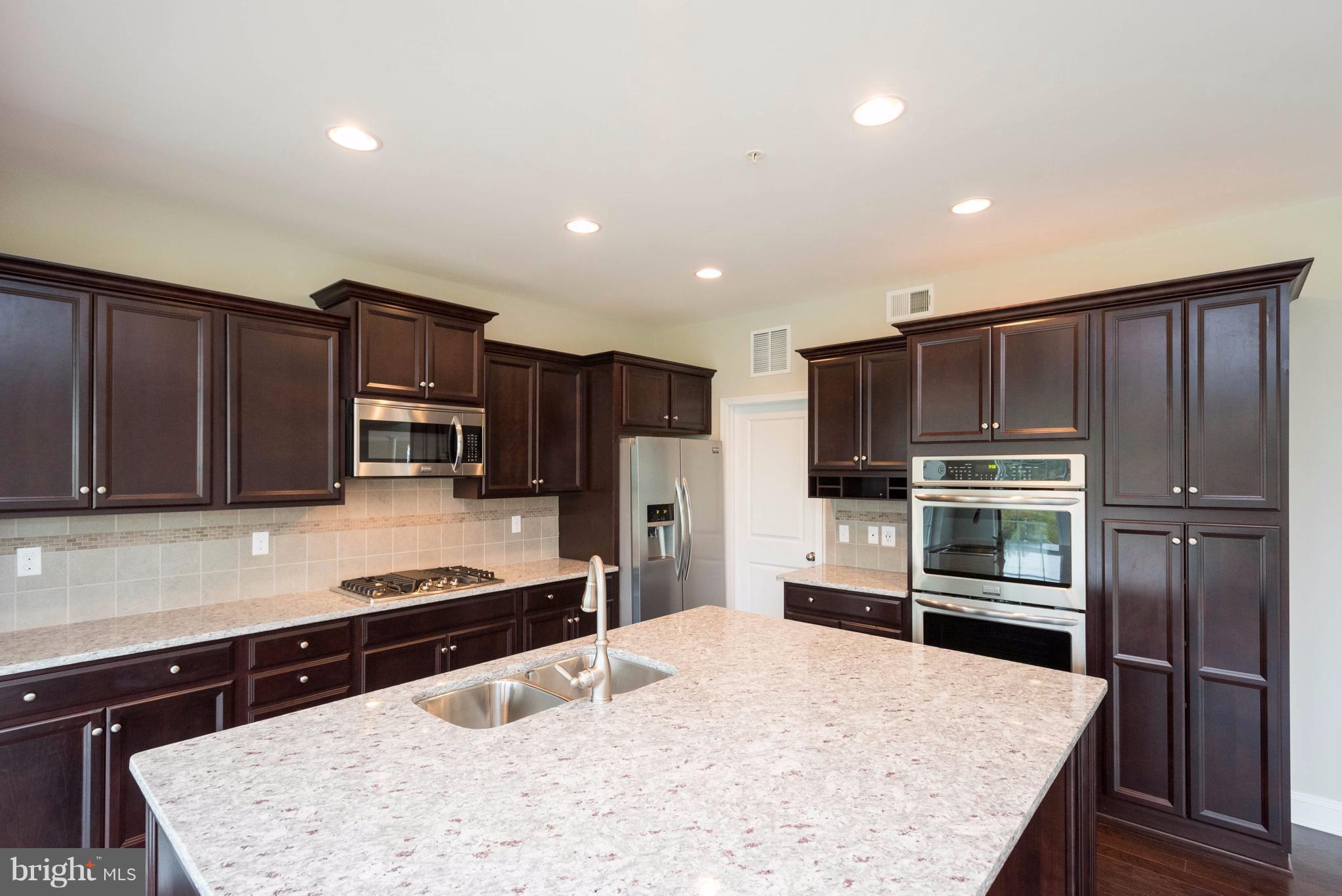 9766 Powder Hall Road Perry Hall, MD 21128 - Photo 10 of 30 a kitchen with stainless steel appliances a stove cabinets and refrigerator