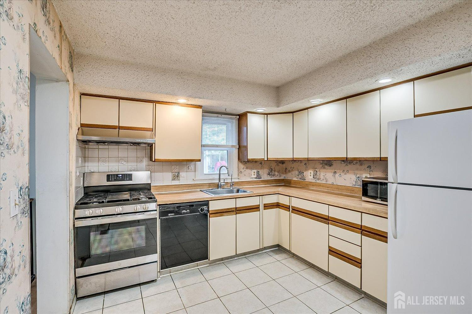 4702 Hana Road Edison, NJ 08817 - Photo 11 of 28 a kitchen with a stove sink and refrigerator