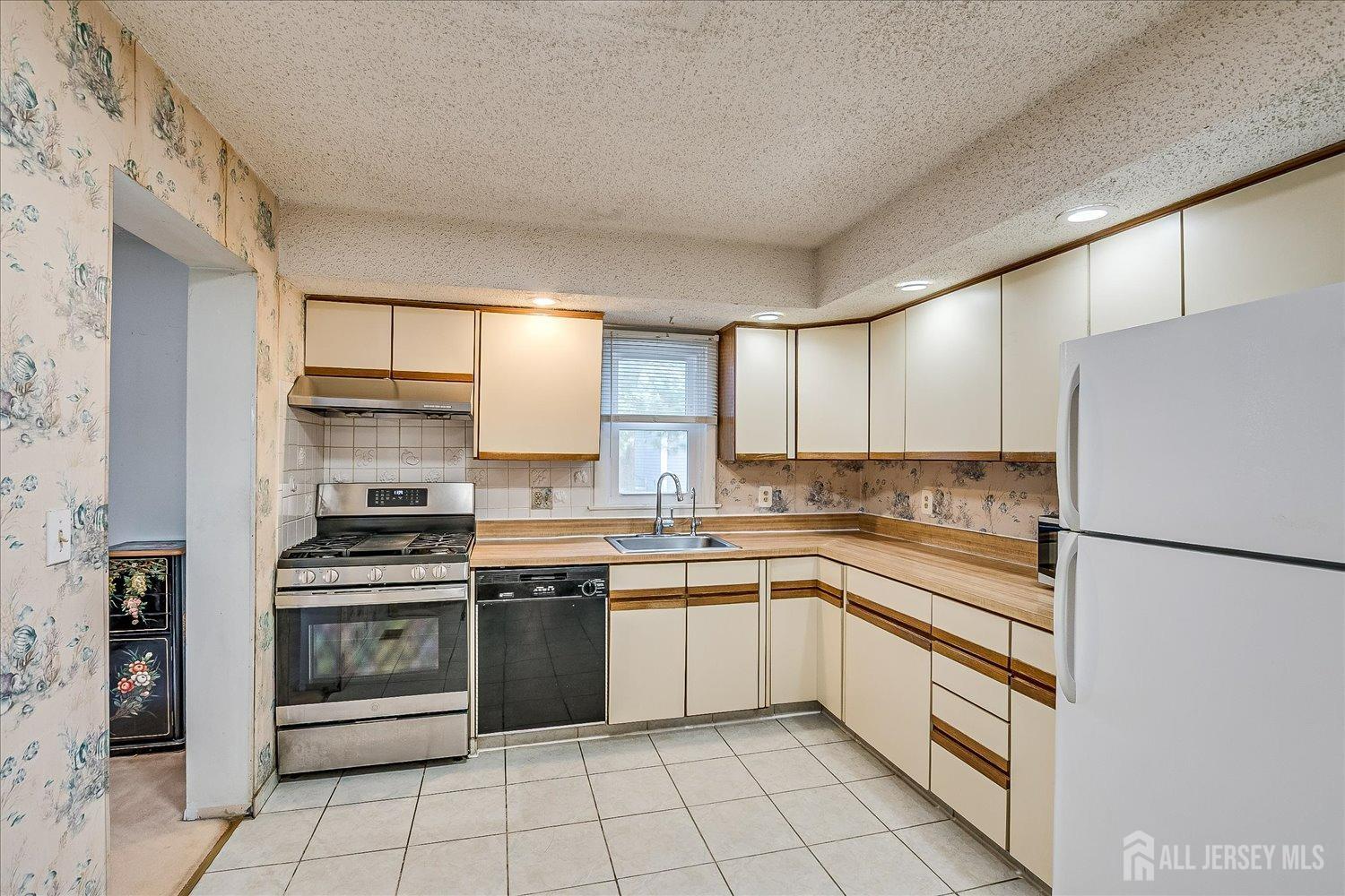 4702 Hana Road Edison, NJ 08817 - Photo 13 of 28 a kitchen with a stove sink and cabinets