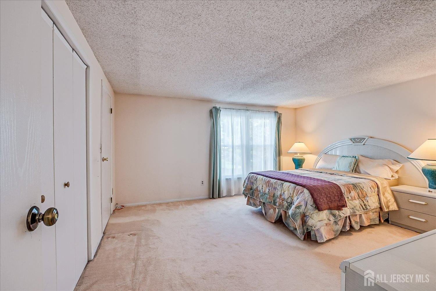 4702 Hana Road Edison, NJ 08817 - Photo 16 of 28 a spacious bedroom with a bed and window