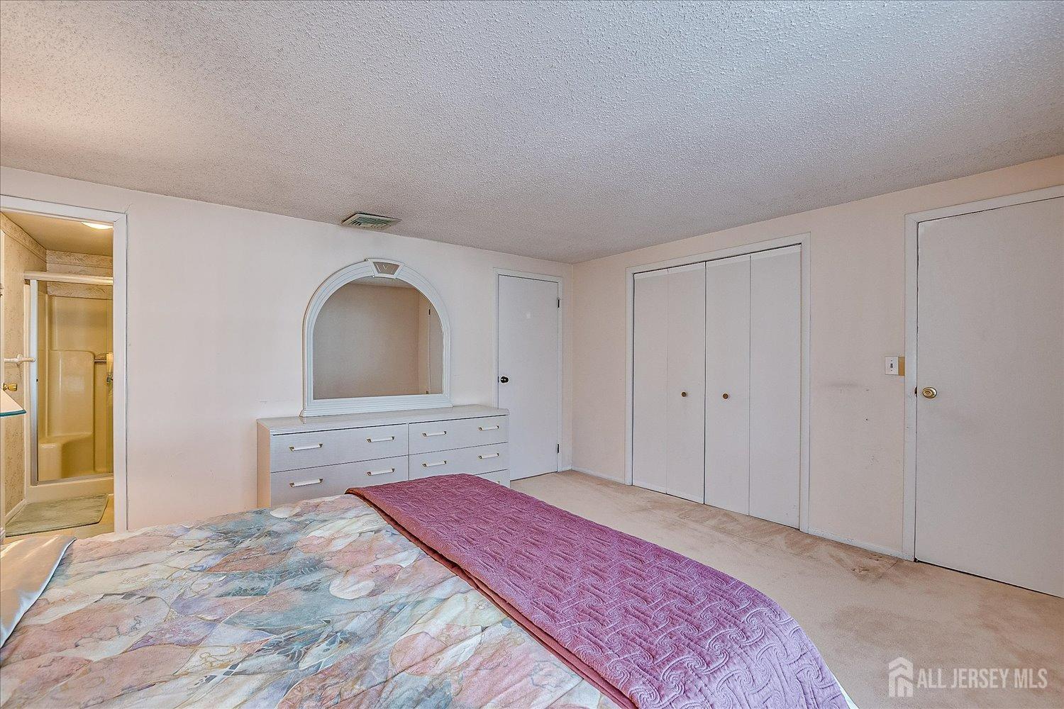 4702 Hana Road Edison, NJ 08817 - Photo 17 of 28 a bedroom with a bed and a dresser