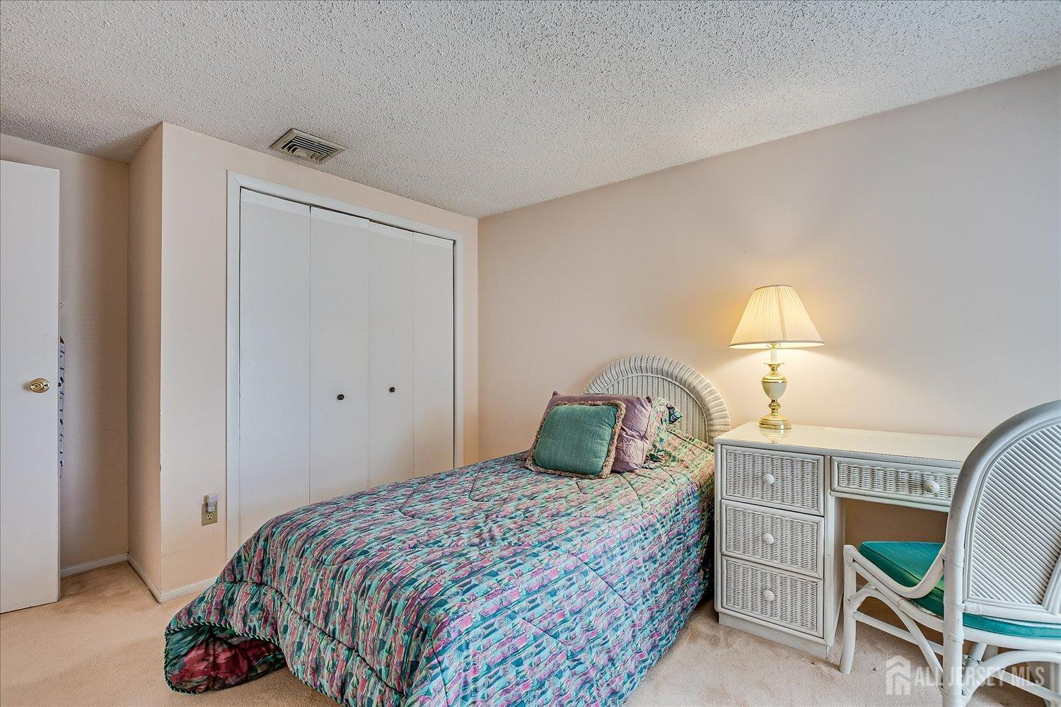 4702 Hana Road Edison, NJ 08817 - Photo 24 of 28 a bedroom with a bed and a lamp