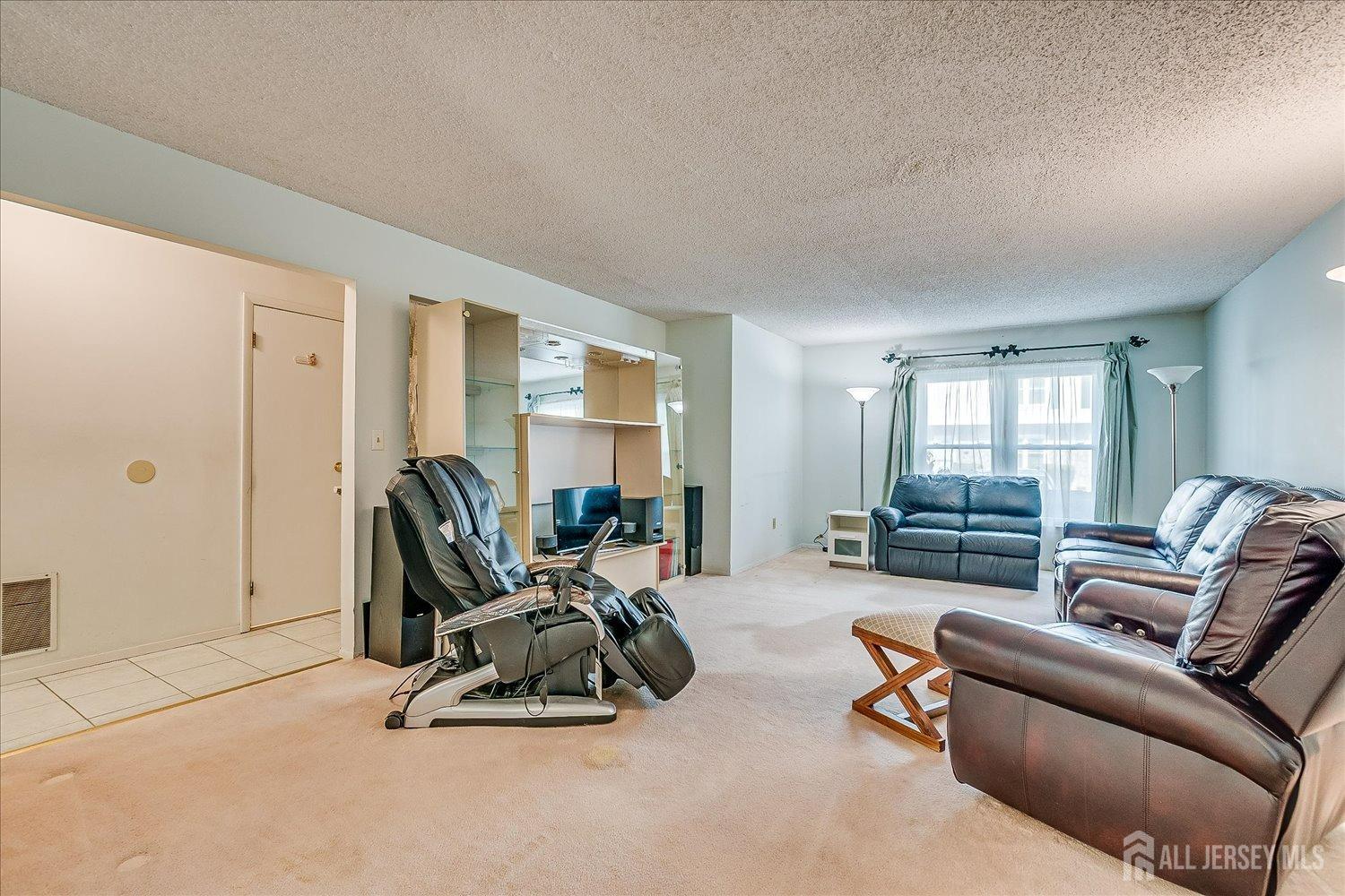 4702 Hana Road Edison, NJ 08817 - Photo 4 of 28 a living room with furniture gym equipment and a large window