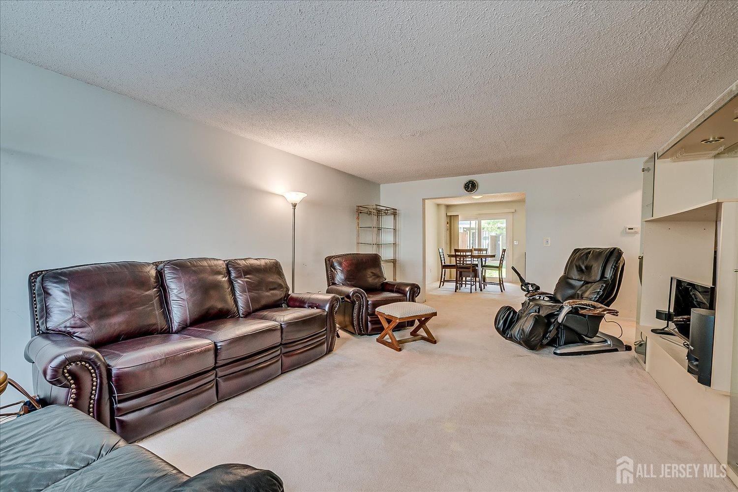 4702 Hana Road Edison, NJ 08817 - Photo 6 of 28 a living room with furniture a large window and gym equipment