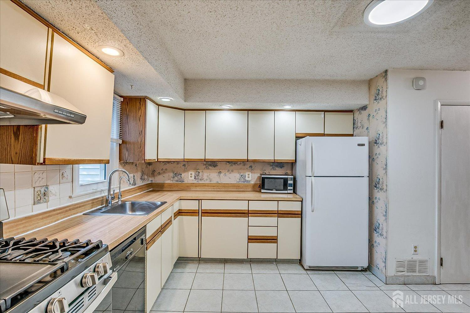 4702 Hana Road Edison, NJ 08817 - Photo 10 of 28 a kitchen with a refrigerator a stove and a sink