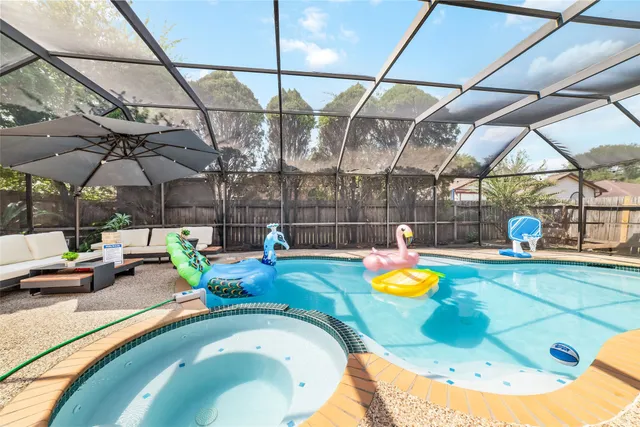 a view of a swimming pool with a chairs and wooden fence