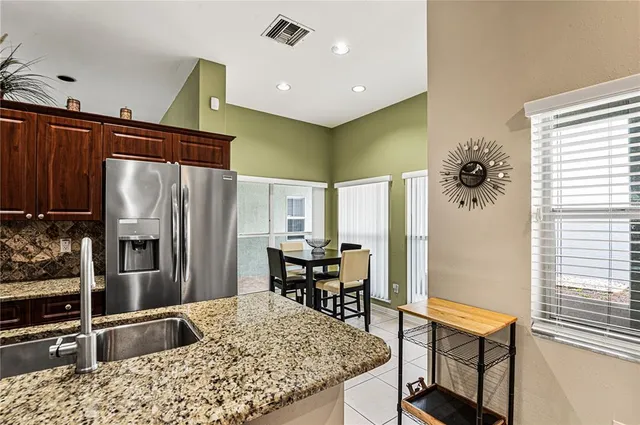 a kitchen with stainless steel appliances kitchen island granite countertop a refrigerator and a stove top oven