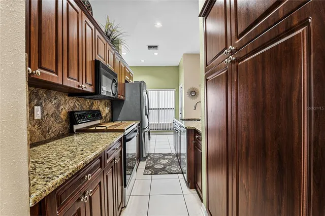 a kitchen with stainless steel appliances granite countertop a refrigerator and a stove top oven