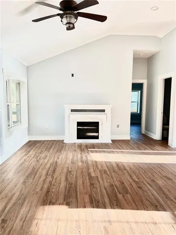 a view of empty room with wooden floor and fireplace
