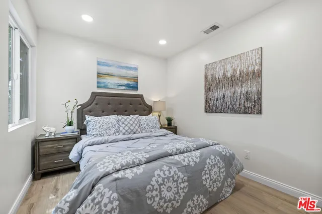 a bedroom with a bed and a painting on the wall